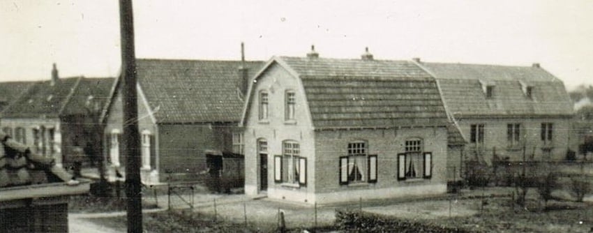 Achter de paal de kosterswoning en daarachter het gebouw van Christelijke Belangen